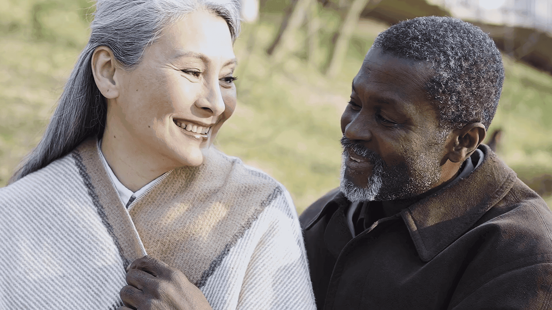 Ein Paar schaut sich draußen lächelnd an